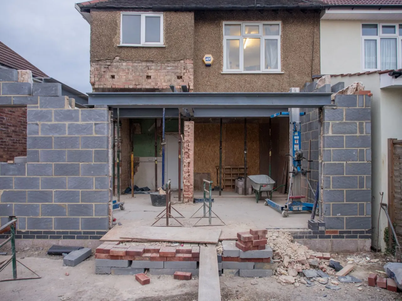House extension under construction with masonry rubble and materials.