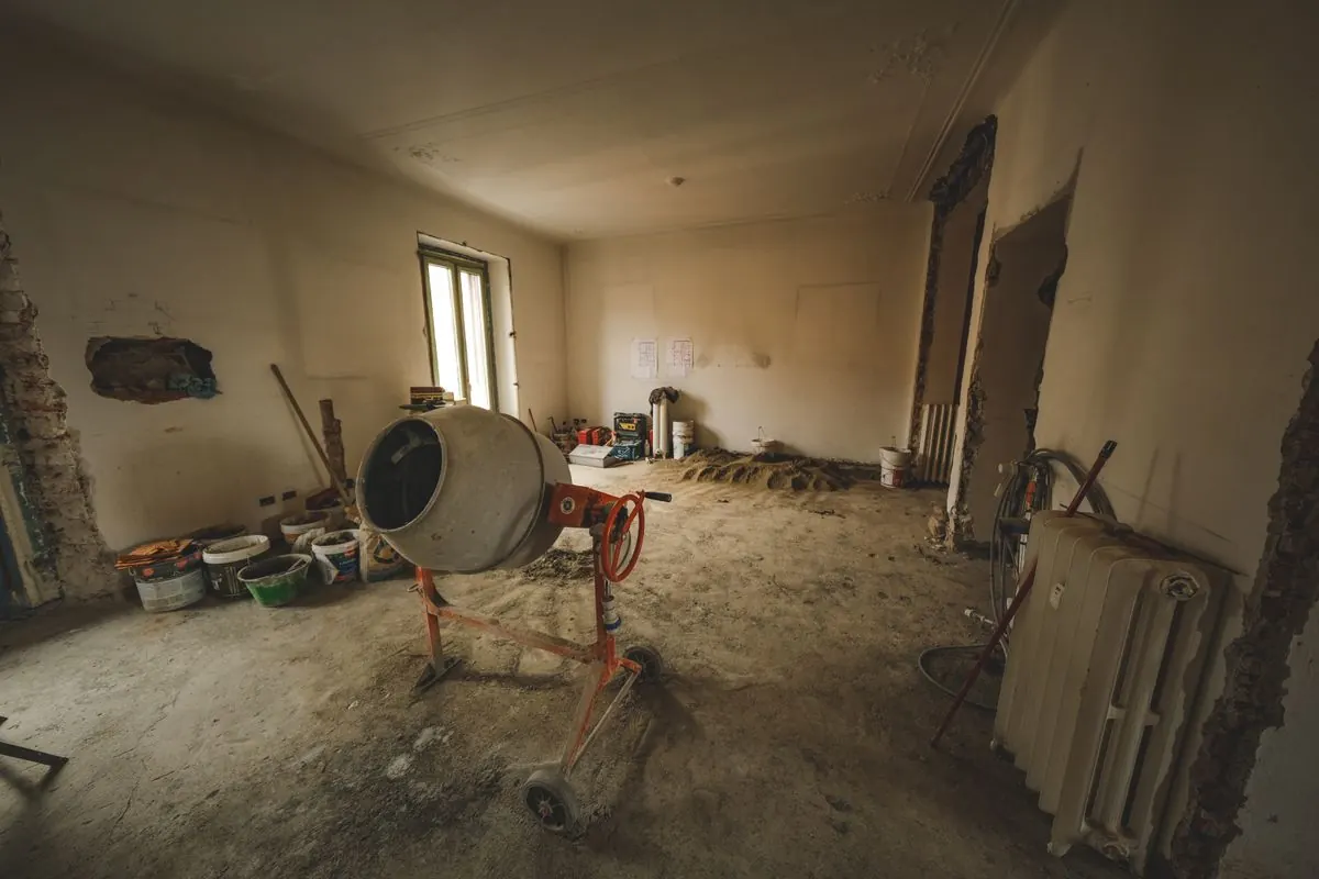 Room undergoing renovation with stripped walls and building materials.